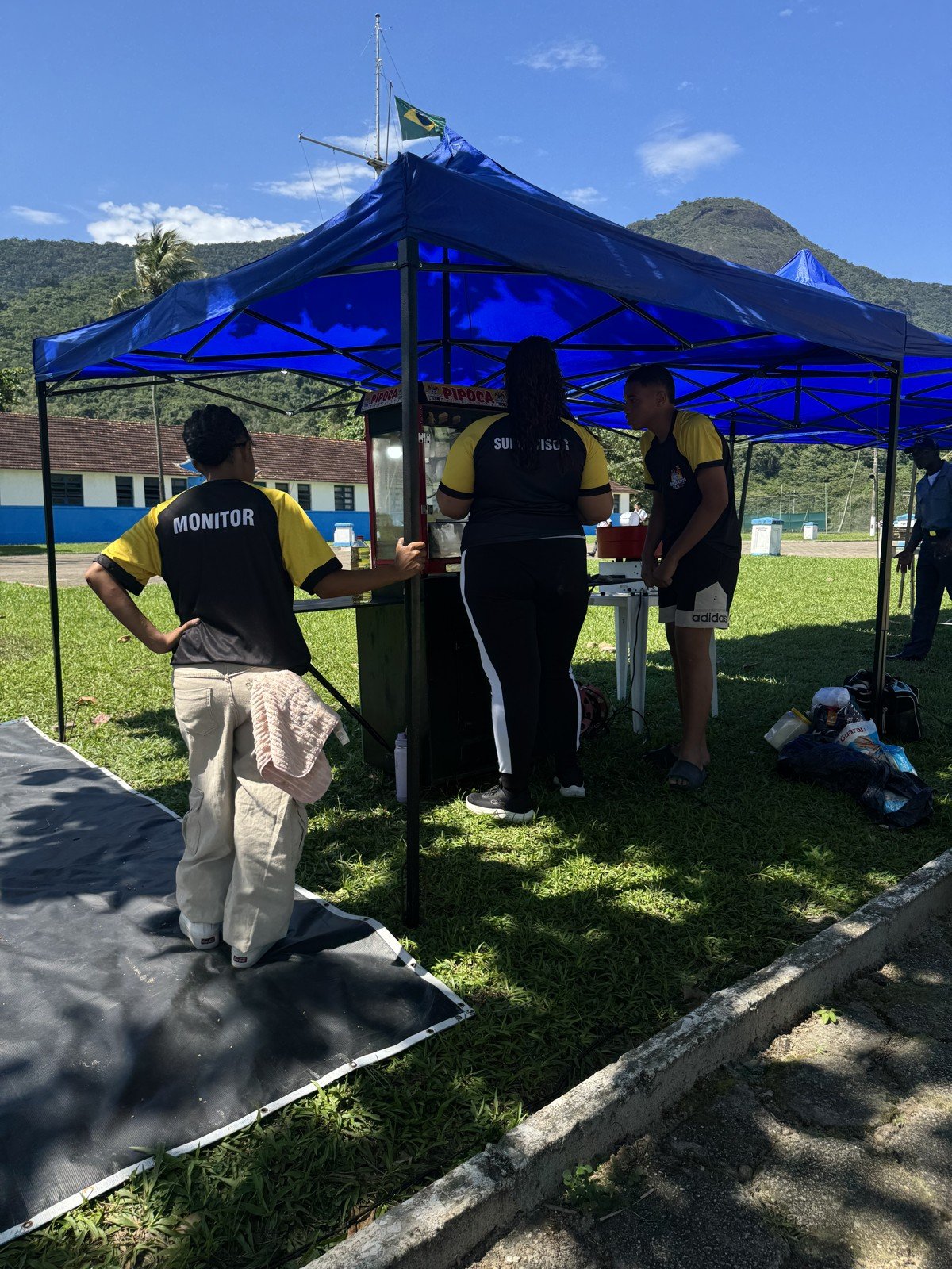 Equipe organizando a estação de pipoca sob a tenda
